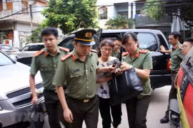 Cơ quan an ninh đưa bà Nguyễn Thị Hồng Nga, chuyên viên phòng Khảo thí và Quản lý chất lượng, Sở Giáo dục và Đào tạo tỉnh Sơn La, thư ký Ban chỉ đạo, ủy viên tổ chấm thi trắc nghiệm về nhà riêng để kiểm tra, khám xét. (Ảnh: Hữu Quyết/TTXVN)
