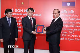 Bộ trưởng Bộ Thông tin, Văn hóa và Du lịch Lào Bosengkham Vongdara trao tặng Huân chương Tự do Isala hạng Nhì cho TTXVN. (Ảnh: Văn Điệp/TTXVN)