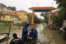 Người dân ở xã Quảng Thọ, huyện Quảng Điền đi lại bằng thuyền. (Ảnh: Hồ Cầu/TTXVN)