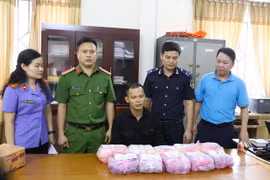 Đối tượng Nguyễn Thành Luân (giữa) và tang vật bị thu giữ. (Ảnh: TTXVN phát)