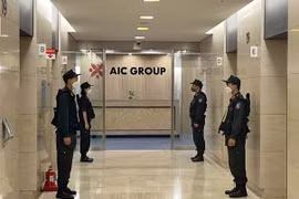 Lực lượng Cảnh sát điều tra làm nhiệm bảo vệ trong quá trình khám xét tại trụ sở Công ty AIC, 69 phố Tuệ Tĩnh, ngày 29/4/2022. (Ảnh: Phạm Kiên/TTXVN)
