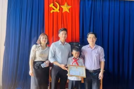 Ủy ban Nhân dân xã Kim Tân tặng Giấy khen cho em Kpă Nguyên vì đã có hành động dũng cảm cứu người bị đuối nước. (Ảnh: Quang Thái/TTXVN)