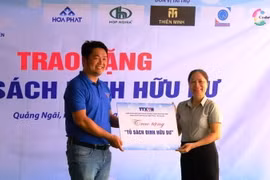 Ban tổ chức trao bảng tượng trưng Tủ sách Đinh Hữu Dư cho Ban giám hiệu Trường. (Ảnh: Đinh Hương/TTXVN)