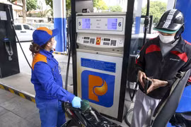 Nhân viên Petrolimex đang bán xăng cho khách hàng. (Ảnh: Đức Duy/Vietnam+)