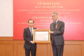 Ông Lê Hoài Trung, Ủy viên Trung ương Đảng, Trưởng Ban Đối ngoại Trung ương trao Huân chương Hữu nghị của Chủ tịch nước cho ông Miguel Mejia, Tổng Bí thư Đảng Phong trào cánh tả thống nhất Dominica. (Ảnh: Phương Hoa/TTXVN)
