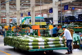 Công nhân làm việc trong nhà máy sản xuất thảm cỏ nhân tạo, Công ty TNHH CCGrass Việt Nam ở Khu công nghiệp Phước Đông, huyện Gò Dầu. (Ảnh: Hồng Đạt/TTXVN)