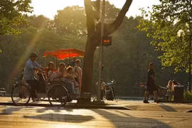 Du khách trải nghiệm du lịch quanh hồ Hoàn Kiếm bằng xích lô. (Ảnh: Khánh Hòa/TTXVN)