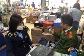 Lực lượng chức năng đang kiểm tra thiết bị đo nồng độ cồn tại cửa hàng kinh doanh thiết bị y tế trên phố Phương Mai. (Ảnh: Uyên Hương/BNEWS/TTXVN)