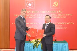 Ông Lê Hoài Trung, Ủy viên Trung ương Đảng, Trưởng Ban Đối ngoại Trung ương và ông Miguel Mejia, Tổng Bí thư Đảng Phong trào cánh tả thống nhất Dominica trao bản thỏa thuận hợp tác giữa hai Đảng. (Ảnh: Phương Hoa/TTXVN)