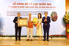 Nguyên Bộ trưởng Bộ Thông tin và Truyền thông, Chủ tịch Hội đồng xác lập Tổ chức Kỷ lục Việt Nam Lê Doãn Hợp trao bằng xác lập kỷ lục và Kỷ niệm chương của Tổ chức Kỷ lục Việt Nam cho nghệ sỹ nhiếp ảnh Vũ Hải. (Nguồn: Báo Vĩnh Phúc)