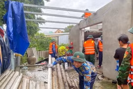 Bộ đội Biên phòng tỉnh Thừa Thiên-Huế phối hợp với chính quyền địa phương hỗ trợ các gia đình bị thiệt hại lợp lại, gia cố mái nhà. (Ảnh: TTXVN phát)