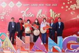 Ban tổ chức tặng hoa và quà cho những du khách quốc tế "xông đất" Đà Nẵng đầu năm mới Quý Mão 2023 bằng đường hàng không. (Ảnh: Trần Lê Lâm/TTXVN)