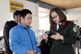 Cán bộ Phòng quản lý Xuất nhập cảnh hướng dẫn người dân làm thủ tục hộ chiếu trực tuyến. (Ảnh: Công Tường/TTXVN)