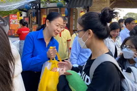 Bí thư Thành Đoàn Thành phố Hồ Chí Minh Phan Thị Thanh Phương trao quà Tết cho sinh viên, người lao động trước giờ lên xe. (Ảnh: Hồng Giang/TTXVN)