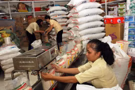 Đóng gói gạo ở Công ty Lương thực Trà Vinh. (Ảnh: Đình Huệ/TTXVN)