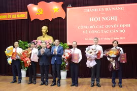 Bí thư Thành ủy Đà Nẵng Nguyễn Văn Quảng (thứ 3 từ trái sang) và Chủ tịch UBND thành phố Đà Nẵng Lê Trung Chinh (thứ 4 từ trái sang) trao quyết định và tặng hoa chúc mừng các cán bộ được điều động, luân chuyển. (Ảnh: Quốc Dũng/TTXVN)