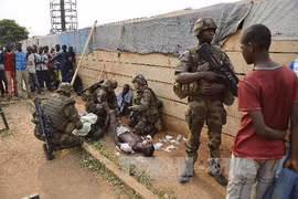 Binh sỹ Pháp giúp đỡ người bị thương trong các vụ cướp phá tại Bangui. (Ảnh: AFP/TTXVN)