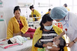 Nhân viên y tế kiểm tra sức khỏe cho bệnh nhi tại Bệnh viện Sản-Nhi Bắc Giang. (Ảnh: Dương Ngọc/TTXVN)