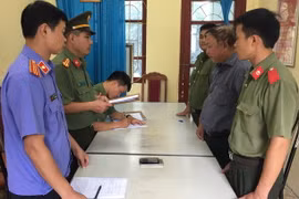 Đối tượng Nguyễn Hồng Bài (áo kẻ) tại cơ quan Công an. (Ảnh: Nguyễn Cường/TTXVN)