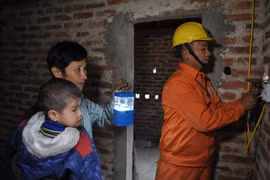 Lắp đặt điện hỗ chợ hộ nghèo. (Ảnh Hoa Việt Cường/TTXVN)