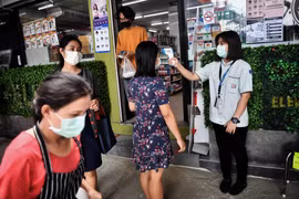 Kiểm tra thân nhiệt cho người dân tại Bangkok, Thái Lan. (Ảnh: AFP/TTXVN)