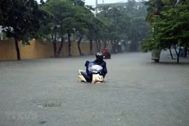 Đường Trường Chinh, thành phố Điện Biên Phủ ngập sâu trong nước. (Ảnh: Phan Tuấn Anh/TTXVN)