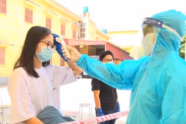 Bác sĩ kiểm tra thân nhiệt cho công dân. (Ảnh: Đinh Tuấn/TTXVN)