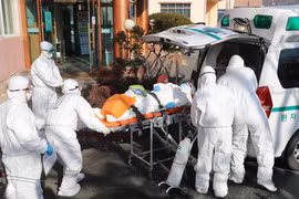 Nhân viên y tế chuyển bệnh nhân nhiễm virus SARS-CoV-2 lên xe cứu thương tại thành phố Daehu, Hàn Quốc. (Ảnh: AFP/TTXVN)