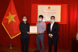 Đại sứ đặc mệnh toàn quyền nước CHXHCN Việt Nam tại Canada Phạm Cao Phong trao khẩu trang cho đại diện bà con cộng đồng người Việt tại thành phố Montreal. (Ảnh: Quang Thịnh/TTXVN)