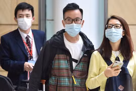 Hành khách đeo khẩu trang phòng dịch viêm phổi do virus corona. (Ảnh: AFP/TTXVN)