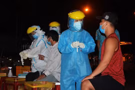Nhân viên y tế đang lấy mẫu xét nghiệm của người dân tại cảng cá Thọ Quang (Đà Nẵng). (Ảnh: Văn Dũng/TTXVN)