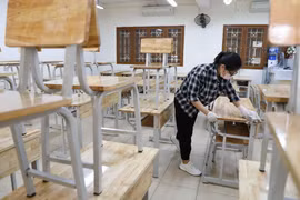 Vệ sinh, khử khuẩn bàn ghế trong lớp học trường THPT Kim Liên, quận Đống Đa, Hà Nội. (Ảnh: Thanh Tùng/TTXVN)