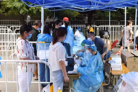 Nhân viên y tế lấy mẫu dịch xét nghiệm COVID-19 cho người dân ở Bắc Kinh, Trung Quốc ngày 26/6. (Ảnh: THX/TTXVN)