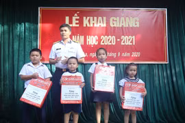 Đại diện chính quyền địa phương thị trấn Trường Sa tặng quà động viên cho các học sinh Trường Tiểu học thị trấn Trường Sa, nhân dịp khai giảng năm học mới. (Ảnh: TTXVN phát)