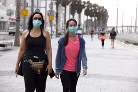 Người dân đeo khẩu trang phòng dịch COVID-19 khi di chuyển tại thành phố miền Trung Tel Aviv. (Ảnh: THX/TTXVN)