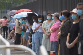 Người dân xếp hàng chờ xét nghiệm COVID-19 tại Bắc Kinh, Trung Quốc. (Ảnh: AFP/TTXVN)