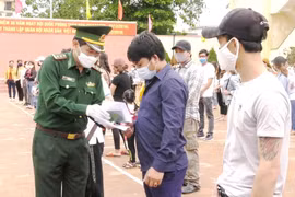 Cán bộ biên phòng trao Giấy chứng nhận hoàn thành cách ly phòng chống dịch bệnh COVID-19 cho các công dân. (Ảnh: Võ Dung/TTXVN)