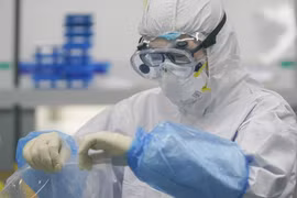 Kỹ thuật viên xử lý mẫu xét nghiệm axit nucleic tại một phòng thí nghiệm về virus SAR-CoV-2 ở Vũ Hán, Trung Quốc. (Ảnh: THX/TTXVN)