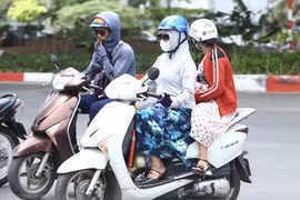 Người dân mặc áo chống nắng khi ra đường. (Ảnh: Minh Quyết/TTXVN)