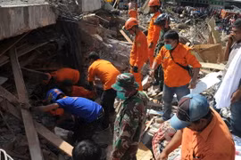 Lực lượng cứu hộ Indonesia tìm kiếm các nạn nhân còn mắc kẹt trong đống đổ nát sau trận động đất tại tỉnh Aceh ngày 7/12. (Nguồn: AFP/TTXVN)