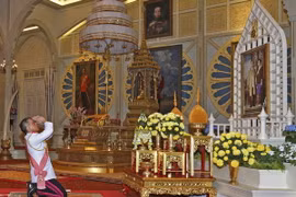 Nhà Vua mới Maha Vajiralongkorn Bodindradebayavarangkun tưởng niệm trước chân dung Nhà Vua quá cố Bhumibol Adulyadej tại lễ lên ngôi ở Bangkok ngày 1/12. (Nguồn: AP/TTXVN)