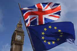 Quốc kỳ Anh (phía trên) và cờ Liên minh châu Âu (EU) phía dưới bên ngoài tòa nhà Quốc hội Anh ở London. (Ảnh: AFP/TTXVN)