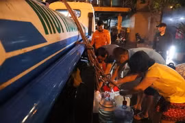 Người dân khu đô thị Hapulico (phường Thanh Xuân Trung, quận Thanh Xuân) xếp hàng chờ nước sạch lúc nửa đêm. (Ảnh: Thành Đạt/TTXVN)