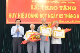 Phó Bí thư Thường trực Thành ủy TP.HCM Trần Lưu Quang trao Huy hiệu Đảng cho các đảng viên thuộc Đảng bộ huyện Hóc Môn. (Ảnh minh họa. Nguồn: hcmcpv.org.vn)