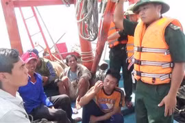 Cán bộ, chiến sỹ biên phòng Quảng Bình trò chuyện, thăm hỏi tình hình các thuyền viên tàu bị nạn. (Ảnh: Châu Thành/TTXVN)