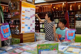 Phụ huynh xem bảng giá niêm yết sách giáo khoa tại cửa hàng thuộc hệ thống phân phối chính thức của NXB Giáo dục Việt Nam. (Ảnh minh họa: Thanh Tùng/TTXVN)