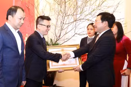 Phó Thủ tướng, Bộ trưởng Bộ Ngoại giao Phạm Bình Minh trao Bằng khen của Thủ tướng Chính phủ tặng Thông tấn xã Việt Nam. (Ảnh: Văn Điệp/TTXVN)