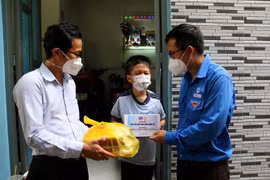 Đoàn thanh niên Tổng Công ty Điện lực Thành phố Hồ Chí Minh và Quận 4 tặng máy tính bảng trong chương trình “Tuổi trẻ EVN thắp sáng niềm tin” cho trẻ mồ côi do dịch COVID-19 ở Quận 4. (Ảnh: Thanh Vũ/TTXVN)