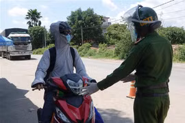 Người từ các tỉnh phía Nam đi xe mô tô về quê được Công an thành phố Đà Nẵng hướng dẫn, đảm bảo an toàn khi đi qua địa bàn thành phố. (Ảnh: Quốc Dũng/TTXVN)