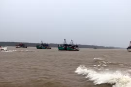 Lực lượng chức năng đường thủy vận động tàu thuyền vào neo đậu trú tránh an toàn hơn. (Ảnh: Trung Hiếu/TTXVN)